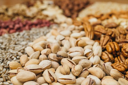Nuts mix in a canvas bag in table. Ten kinds of nuts: pecan, brazil, cedar, sunflower, hazelnut,...