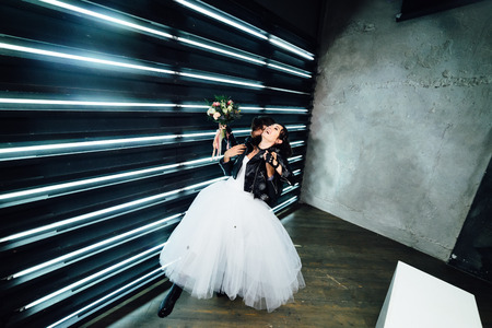 Wedding in the style of rock. Rocker or Biker wedding. Guys with stylish leather jackets. Its a rocknroll baby! Sweet couple in a photo studio. Steep shooting with mirrors and lamps.の写真素材