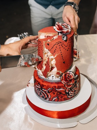 Wedding in the style of rock. Rocker or Biker wedding. Guys with stylish leather jackets. Its a rocknroll baby! A sweet couple is cutting a wedding cake.の写真素材