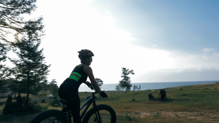 Beautiful girl and her bicycle in the forestの写真素材