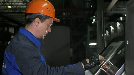 Operator monitors control panel of production line. Manufacture of plastic water pipes of the...