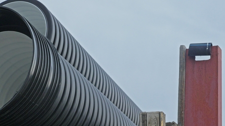 Warehouse of finished plastic pipes industrial outdoors storage site. Manufacture of plastic water pipes factory. Process of making plastic tubes on the machine tool with the use of water and air pressure.の写真素材