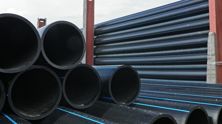 Warehouse of finished plastic pipes industrial outdoors storage site. Manufacture of plastic water...