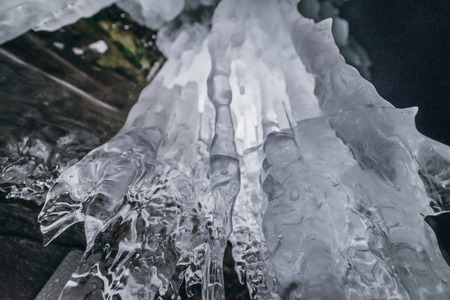 Winter Baikal. Olkhon Island. Ice grotto. Thick blue ice and icicles on the coastal rocks of Olkhon Island in winter. Natural cold background. The winter the lake and the surrounding area becomes ice.の写真素材