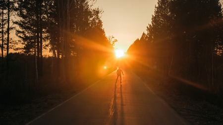 Training an athlete on the roller skaters. Biathlon ride on the roller skis with ski poles, in the...