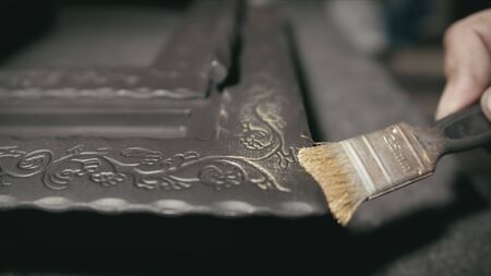 Forge workshop. Smithy manual production. The product is artificially aged. Gold powder painting of scratches, roughness and scuffs. Ageing. Aging processes. Pattern on iron. Carving ornament.の写真素材