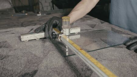 Forge. Smithy. Glass cutting and processing for fireplace doors. Circular glass cutter. Worker cut...