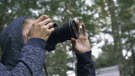 Traveler photographing scenic view in forest. One caucasian woman shooting close up look. Girl take...