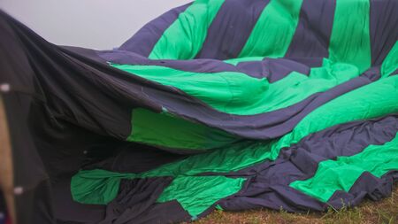 Inflating, unpack and flying up hot air balloon watermelon. Burner directing flame into envelope. Take off aircraft fly in morning blue sky. Start hot air burning to inflate gas fire to air balloon.の写真素材