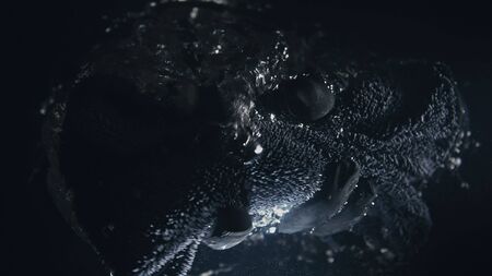 A professional dry microfiber rag for washing a car is dipped in water. Bottom view from under the water. Underwater view of towel in hand in black glove. The tissue in fluid air bubbles and flows.の写真素材
