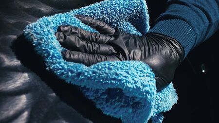 Using rag in palm of your hand, finish liquid car polish are removed from the car.の写真素材