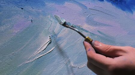 Artist copyist paint seascape with ship in ocean. Craftsman decorator draw as boat sail on blue sea with acrylic oil color.の写真素材