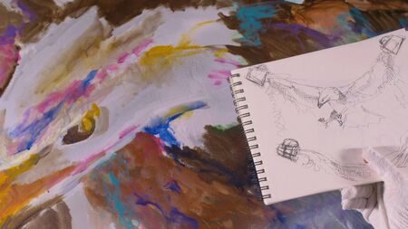 Artist designer draws an eagle on wall. Craftsman decorator paints picture with acrylic oil color...