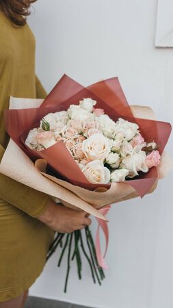 Colorful bouquet of different fresh flowers in the hands of a florist woman. Rustic flower background. Craft bouquet of flowers.の写真素材