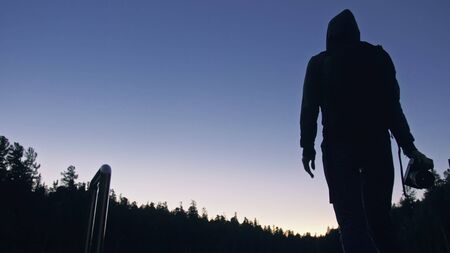 Silhouette traveler photographing scenic view in forest, river. Wood pier. One woman shooting nice...