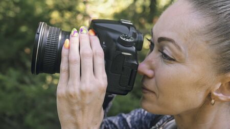 Traveler photographing scenic view in forest. One caucasian woman shooting close up look. Girl take...