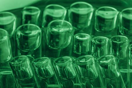 Glass medical ampoule vial for injection. Medicine is liquid sodium chloride with of aqueous solution in ampulla. Close up. Bottles ampule multicolor on background color and water. Human plasma.の写真素材