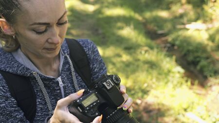 Traveler photographing scenic view in forest. One caucasian woman shooting close up look. Girl take...