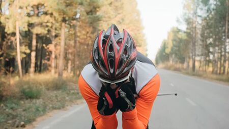 Training an athlete on the roller skaters. Biathlon ride on the roller skis with ski poles, in the helmet. Autumn workout. Roller sport. Adult man riding on skates.の写真素材