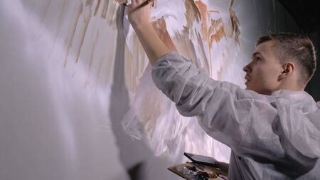 Artist designer draws an eagle on wall. Craftsman decorator paints picture with acrylic oil color...
