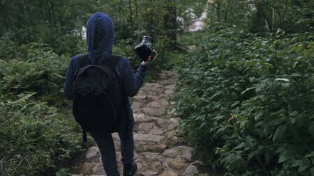 Traveler photographing scenic view in forest. One caucasian woman shooting nice magic look. Girl...