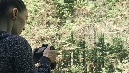 Traveler photographing scenic view in forest. One caucasian woman shooting nice magic look. Girl...