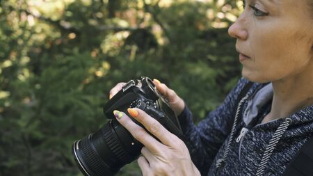 Traveler photographing scenic view in forest. One caucasian woman shooting close up look. Girl take...