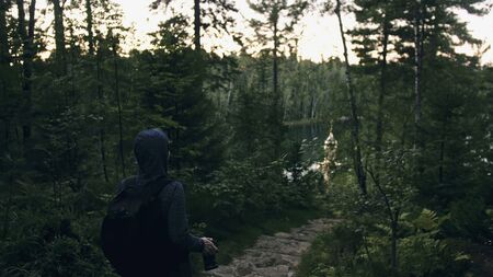 Traveler photographing scenic view in forest. One caucasian woman shooting nice magic look. Girl take photo video on dslr mirrorless camera. Professional photographer travel with backpack. Outdoor.の写真素材