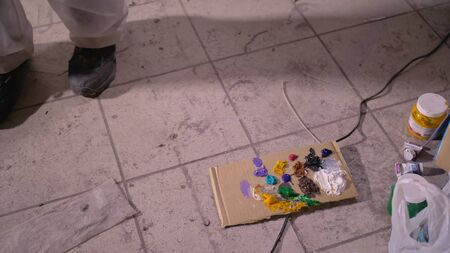 Artist designer draws an eagle on the wall. Craftsman decorator paints a picture with acrylic oil color. Painter painter dressed in a paint coat. Indoor. Dark magic cinematic look.の写真素材