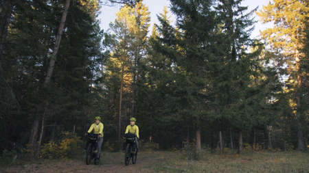 The man and woman travel on mixed terrain cycle touring with bikepacking. The couple journey with...