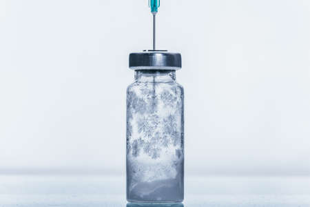 Medicine, Injection, vaccine and disposable syringe, drug concept. Sterile vial medical syringe needle. Macro close up. Glass medical ampoule vial for injection. Bottles ampule with aluminum cap.の写真素材