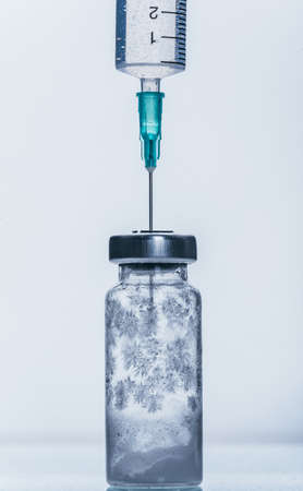 Medicine, Injection, vaccine and disposable syringe, drug concept. Sterile vial medical syringe needle. Macro close up. Glass medical ampoule vial for injection. Bottles ampule with aluminum cap.の写真素材