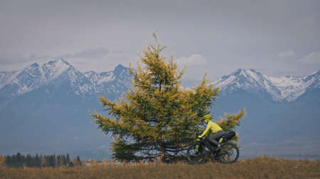 The woman travel on mixed terrain cycle touring with bikepacking. The traveler journey with bicycle bags. Sport tourism bikepacking.の写真素材