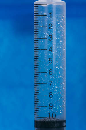 Medicine, Injection, vaccine and disposable syringe isolated, drug concept. Sterile vial medical. Macro close up on backgrounds gray.の写真素材