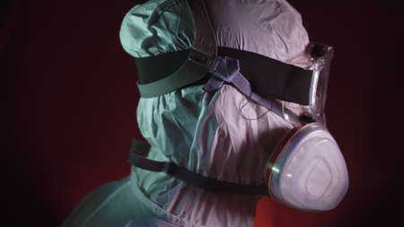 Man in protective costume suit, gas protect medical spray paint mask. Doctor in respirator. Concept...