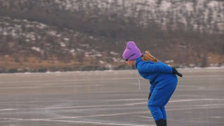 The girl train on ice speed skating. The child skates in the winter in blue sportswear suit, sport...
