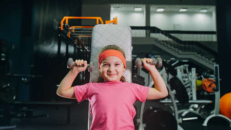 Fit Athletic Baby Girl Work out with Dumbbell, Doing Her Fitnessの写真素材