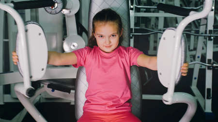 Fit Athletic Baby Girl Work out in Butterfly Pectoral Machine for Chest, Doing Her Fitness Exercise....