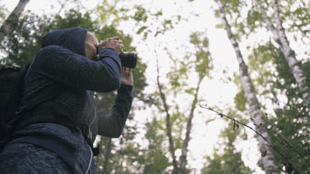 Traveler photographing scenic view in forest. One caucasian woman shooting nice magic look. Girl...