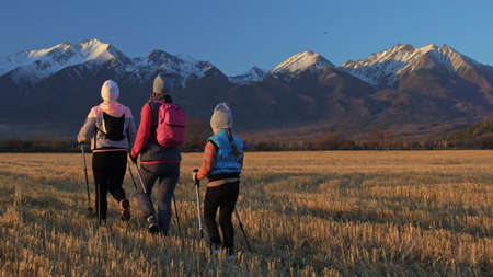 Woman do Nordic walking in nature on background of mountains in