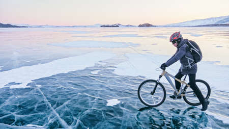 Man is riding bicycle on the ice. Ice of frozen Lake Baikal. Teeの写真素材