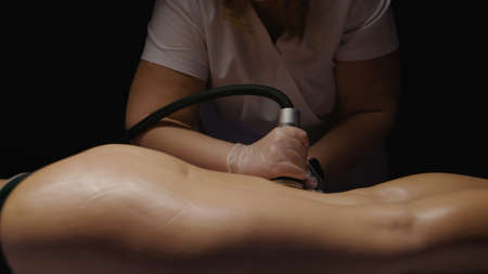 Woman receiving anti-ageing anti-cellulite massage vacuum rf lifting in spa salon. Wellness body and...