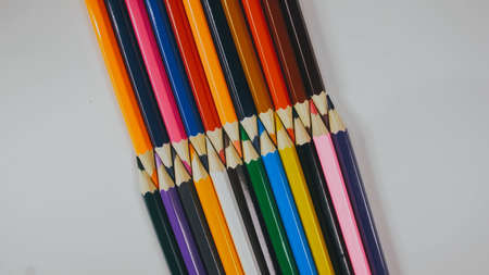 Many colored pencils are arranged around the edges of the imageの写真素材