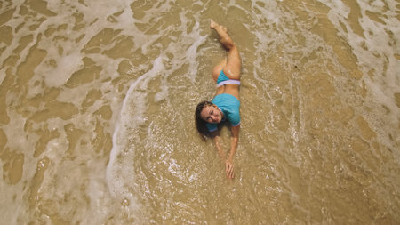 Woman lying on shallow water sea. Happy slightly tipsy woman enj