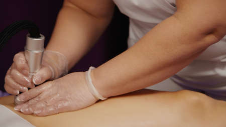 Woman receiving anti-ageing anti-cellulite massage vacuum rf lifting in spa salon. Wellness body and skin care.の写真素材
