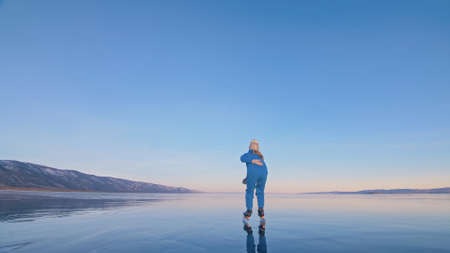 The girl train on ice speed skating. The child skates in the winter in blue sportswear suit, sport glasses. Children speed skating sport.の写真素材