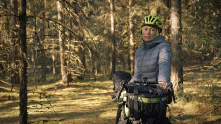 The woman travel on mixed terrain cycle touring with bike bikepacking. The traveler journey with...