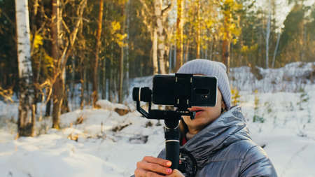 Professional Videographer Holding DSLR Camera on 3-axis Gimbal Stabilization Device in Winter....