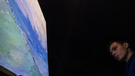 Artist copyist paint seascape with ship in ocean. Craftsman decorator draw as boat sail on blue sea with acrylic oil color. Draw brush, knife palette.の写真素材