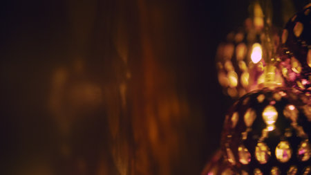 Magic lanterns spin and give beautiful glare to the walls. New Year glowing balls with led diodes are held in hands. Warm lamp light christmas mood.の写真素材